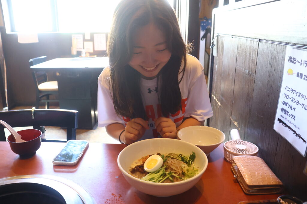 焼肉 がもんのカルボナーラ風冷麺を食べるORANGEスタッフ