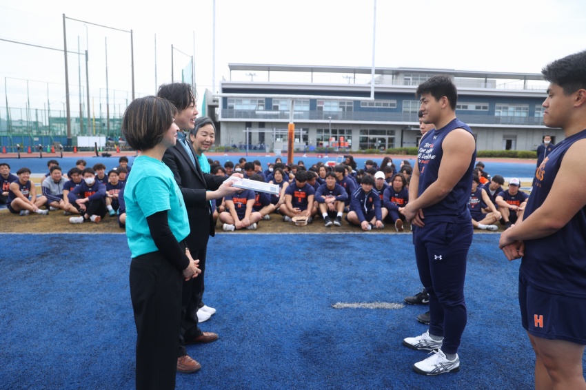 ラッグフリーワールドから感謝状を受け取る法政大学アメフト部の選手たち